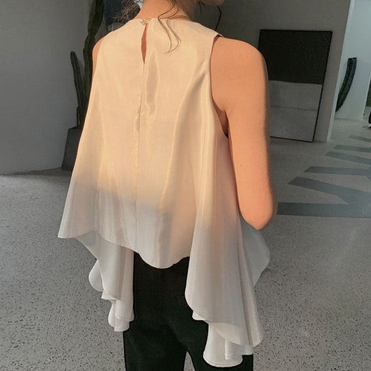 背面から見たホワイトブラウスで、背中のボタン開きとサイドフレアの動きが美しいデザイン