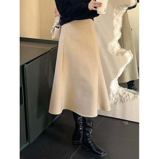 アイボリーのツイードスカートを横から撮影。マーメイドラインが美しく広がるデザイン