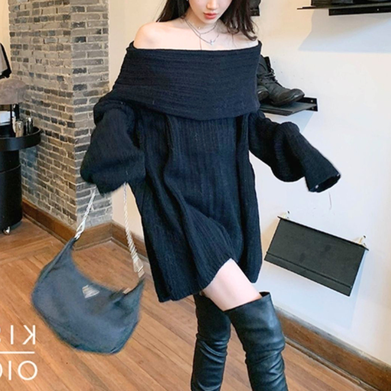 ブラックのニットワンピースを着用した女性の正面。袖を広げた姿と裾の広がりが分かる写真