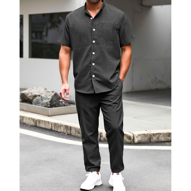 ブラックのリネンライクバンドカラーシャツとイージーパンツセットアップを着た男性の夏コーデ