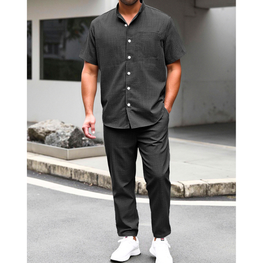 ブラックのリネンライクバンドカラーシャツとイージーパンツセットアップを着た男性の夏コーデ