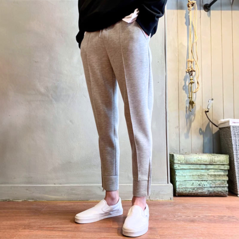 グレーのテーパードアンクルパンツのセンターラインと裾を見せた着用イメージ