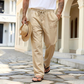 ベージュのコットンリネン混イージーパンツを穿いた男性の正面コーデ