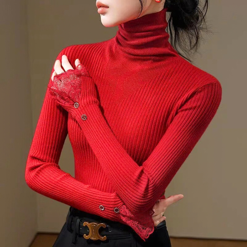 レッドのハイネックリブニットトップス。片腕を胸元に上げ、もう片方の腕を腰に回した姿。縦リブとレースの袖口