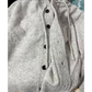 ライトグレーの濃淡のある編み地とフロントボタン、前立てと裾のリブの拡大写真