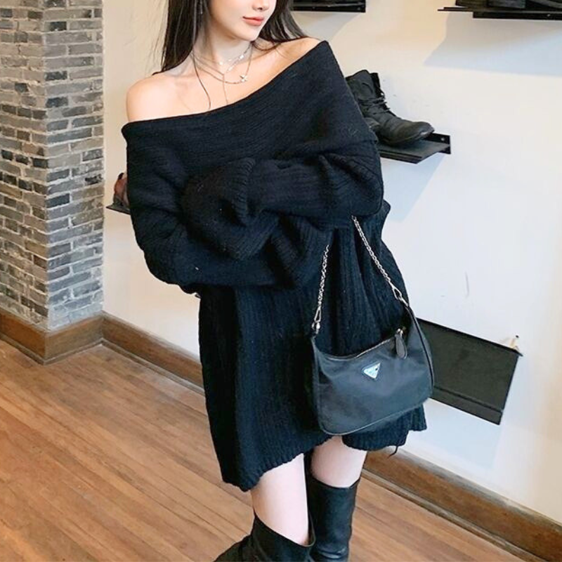 ブラックのニットワンピースを着用した女性のスタイリング。腕を重ねた着こなしとふんわり広がる裾が分かる写真