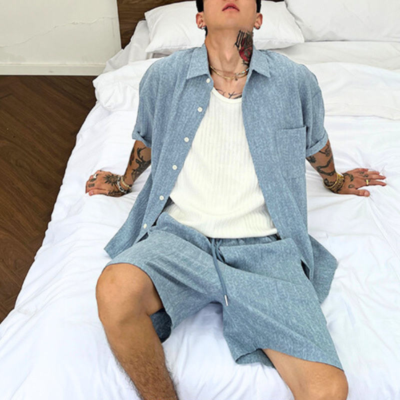 ブルーの縦ライン凹凸リネンセットアップを座って着た男性