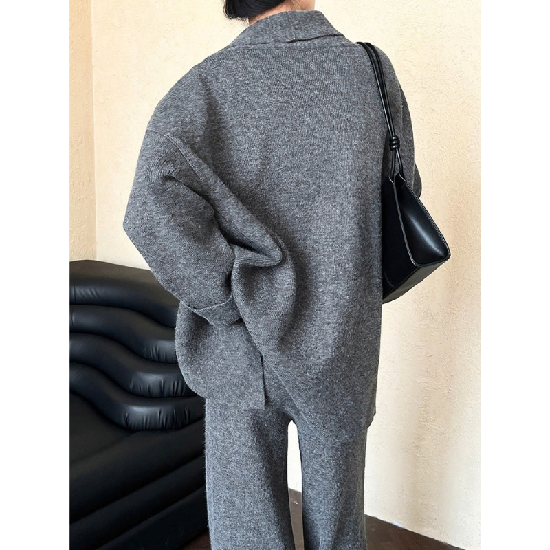 グレーのニット3点セットアップ。背中を向けて立つ姿。カーディガンの背面とワイドパンツの後ろ姿