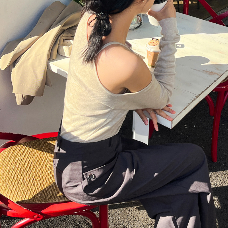 ベージュのワンショルダー風ニットトップスを横から着用したカフェコーデ