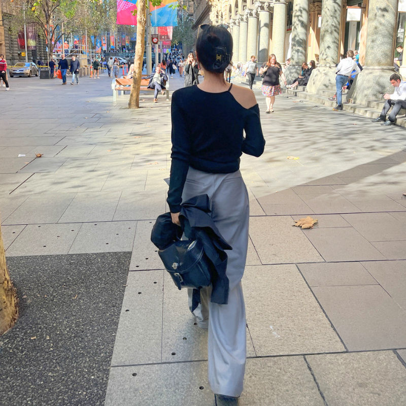 ブラックのアシンメトリーニットトップスを着用した後ろ姿コーデ