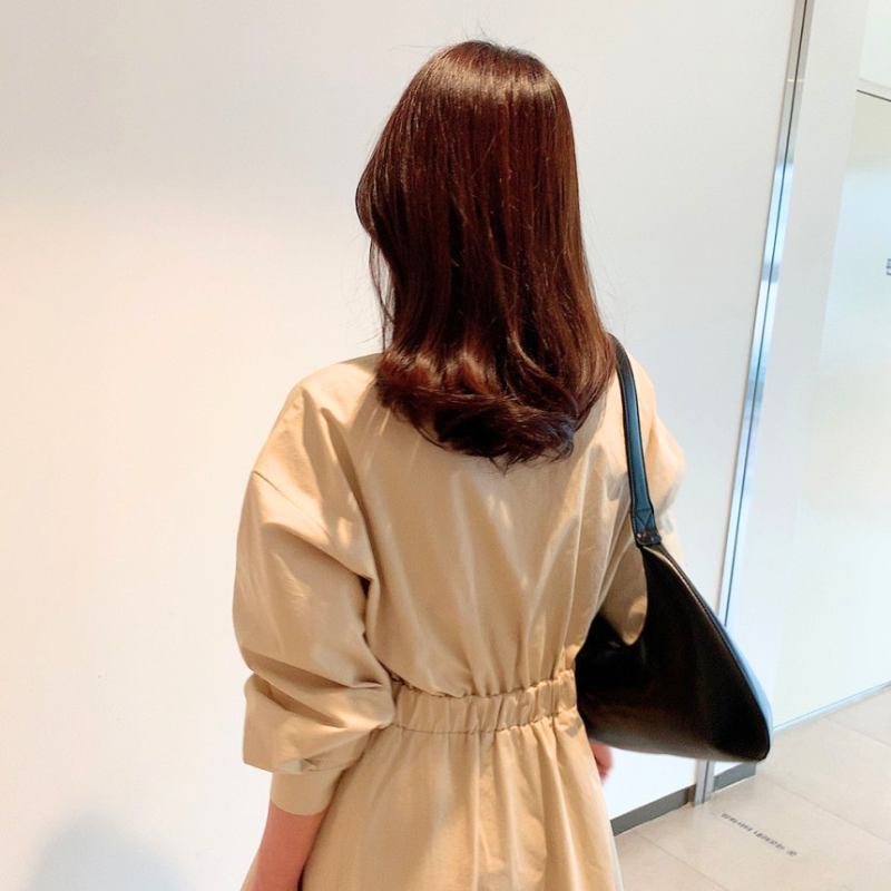 ベージュのワンピースを後ろ姿で着用したスタイル