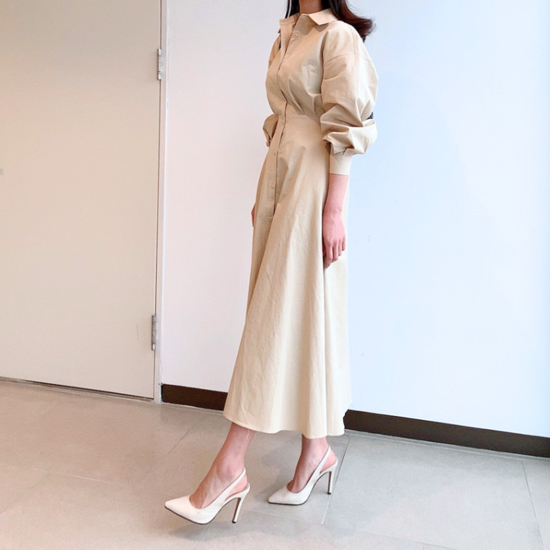 ベージュのフレアシャツワンピースを横から着用した全身シルエット