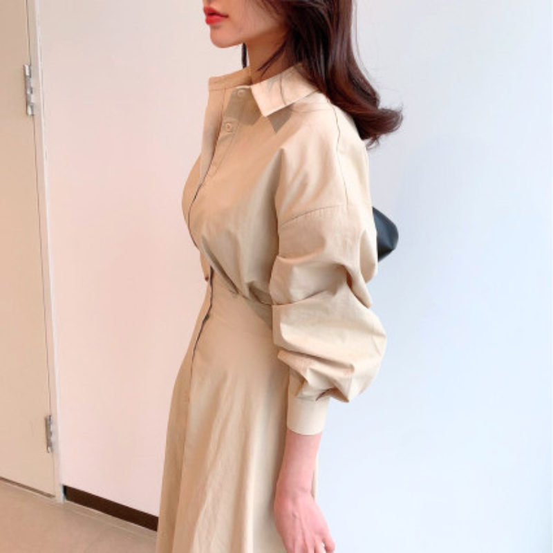 ベージュのウエストマークワンピースを横向きで着用したスタイル