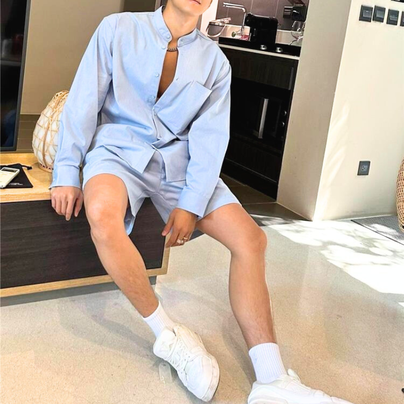 室内でリラックスする男性のセットアップコーデ（ブルー）