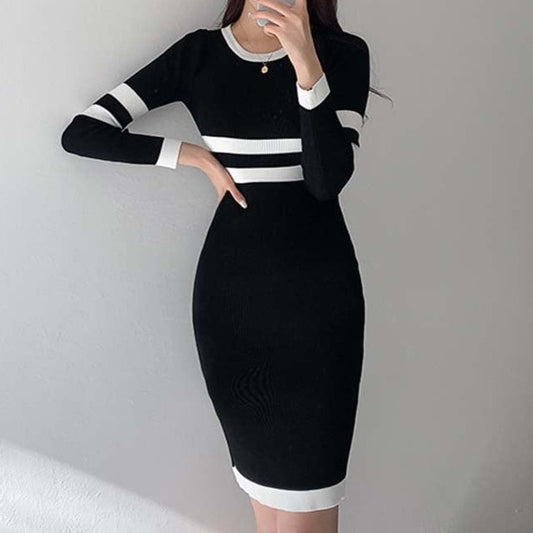正面から撮影したブラックのバイカラーボーダー リブニットワンピースがクルーネックとタイトシルエットで上品な色気を演出