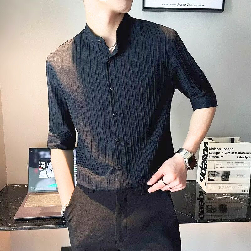 黒の七分袖シャツをボタン開けスタイルで着用した男性