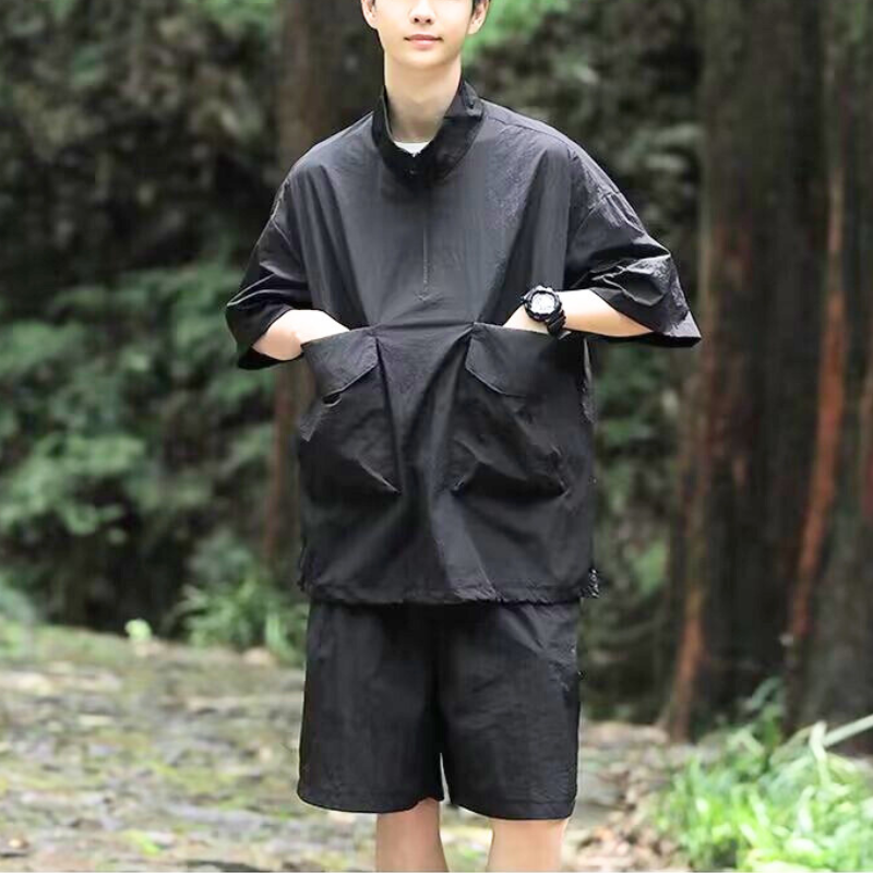 黒い半袖ナイロンセットアップを自然の中で撮影