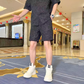 ブラックセットアップで腕を広げた男性モデル