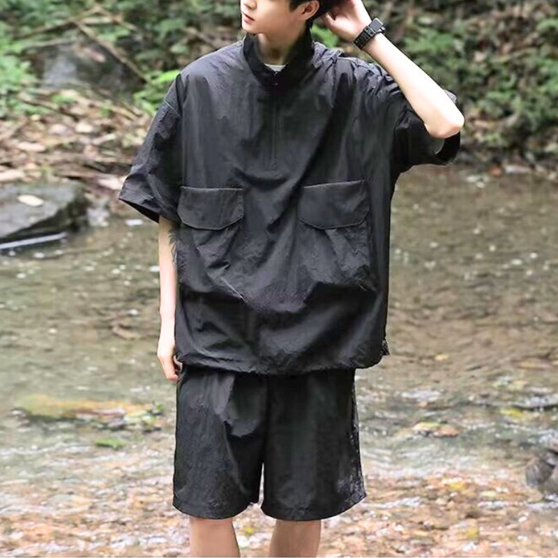 黒の撥水セットアップを着用し、川遊びを楽しむ男性