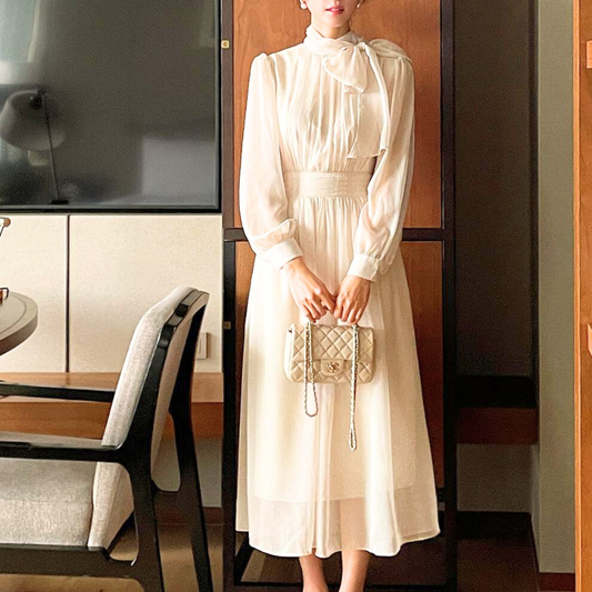 アイボリーのシフォンワンピースを正面から着用する女性