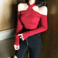 レッドのクロスネックニットトップスを黒ボトムに合わせた着用画像