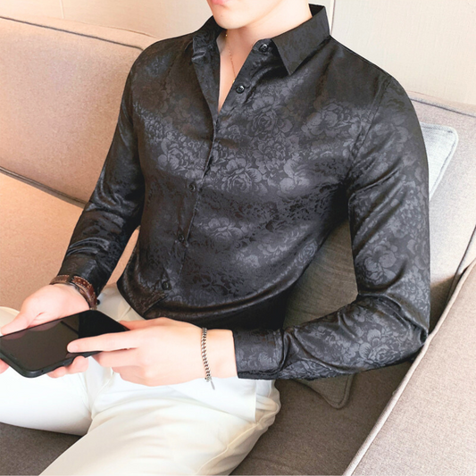 花柄シルク調ブラックシャツを着た男性（座り・スマホ）