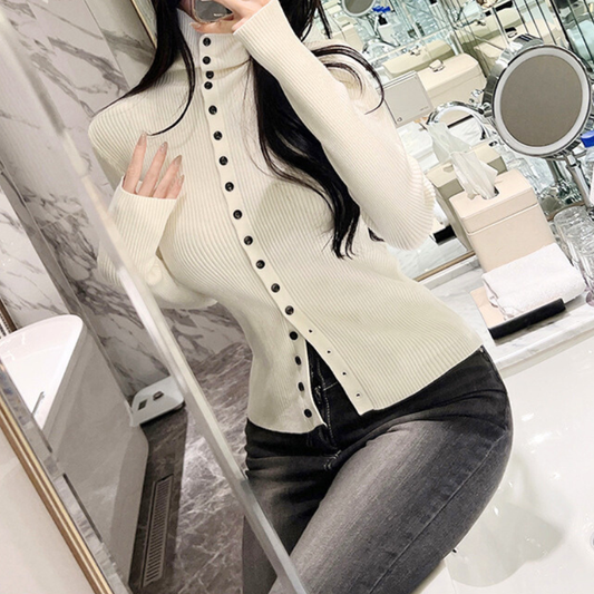 白ニットトップスのフロントボタンデザインが映えるアップ写真。春秋冬の好印象ファッションとして使いやすい細見えニット。