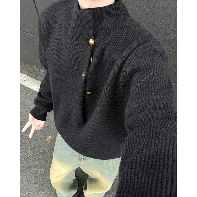 ブラックニットを着た男性の胸元ボタンディテール写真