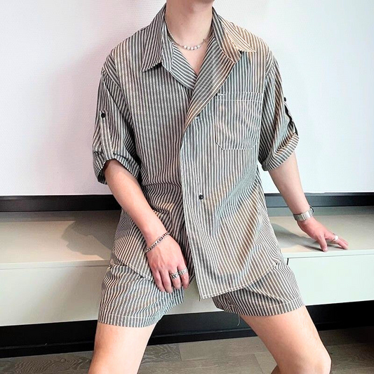 ストライプ柄の開襟シャツとハーフパンツのセットアップを着た男性モデル（座りポーズ）