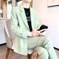 ライトグリーンの爽やかカジュアルスーツ風セットアップを着た男性が椅子に座る写真