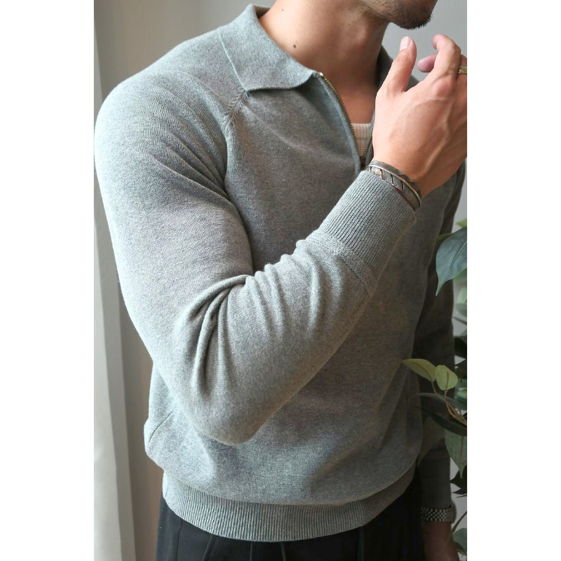 グレーのハーフジップセーターを着た男性の横向きショット