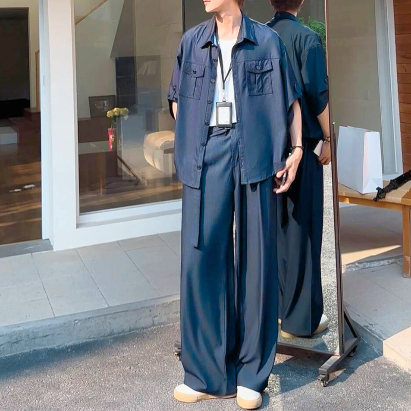 セットアップ姿でミラー前に立つ後ろ姿も映ったスタイル