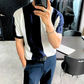 ネイビーのストライプニットをオフィスにきていく男性