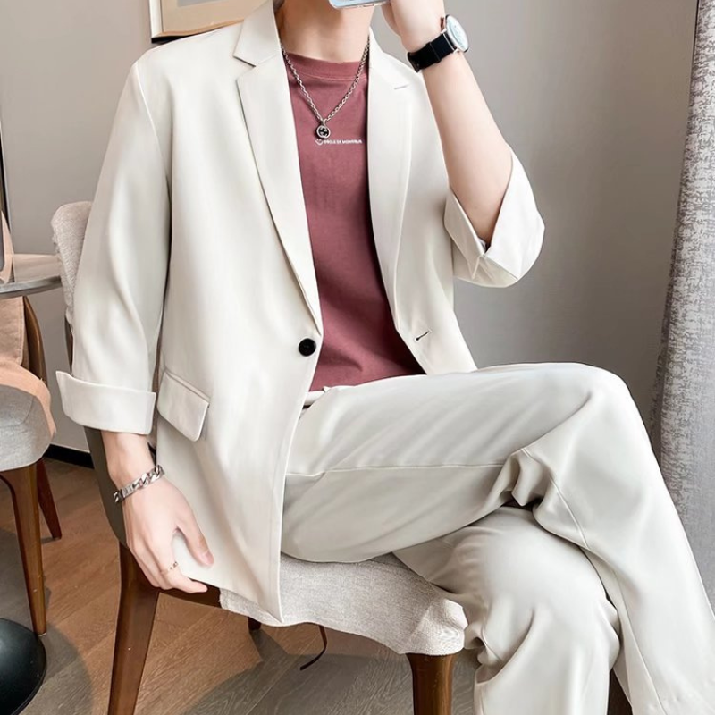 アイボリーのセットアップで脚を組んだラグジュアリーな印象