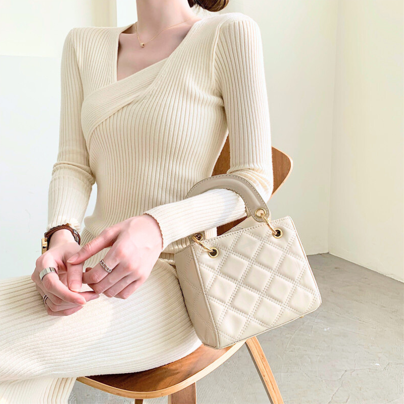 椅子に座る女性が着るアイボリーニットワンピース｜柔らかい日差しに映える大人スタイル