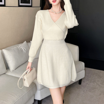 Vネックのアイボリーニットワンピースを着た女性。冬のデートにぴったりな清楚コーデ。