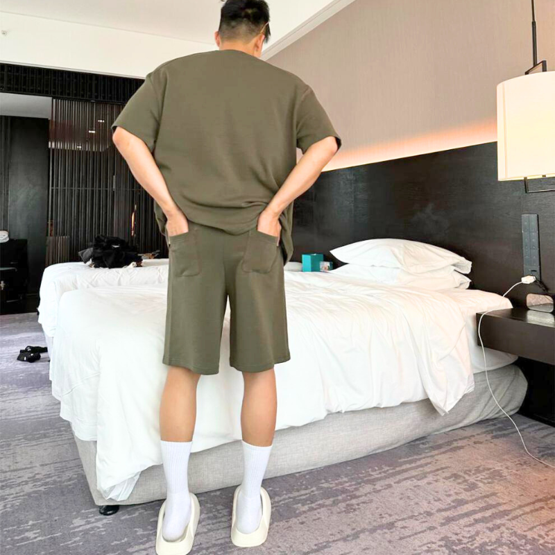 カーキセットアップの後ろ姿を見せる男性