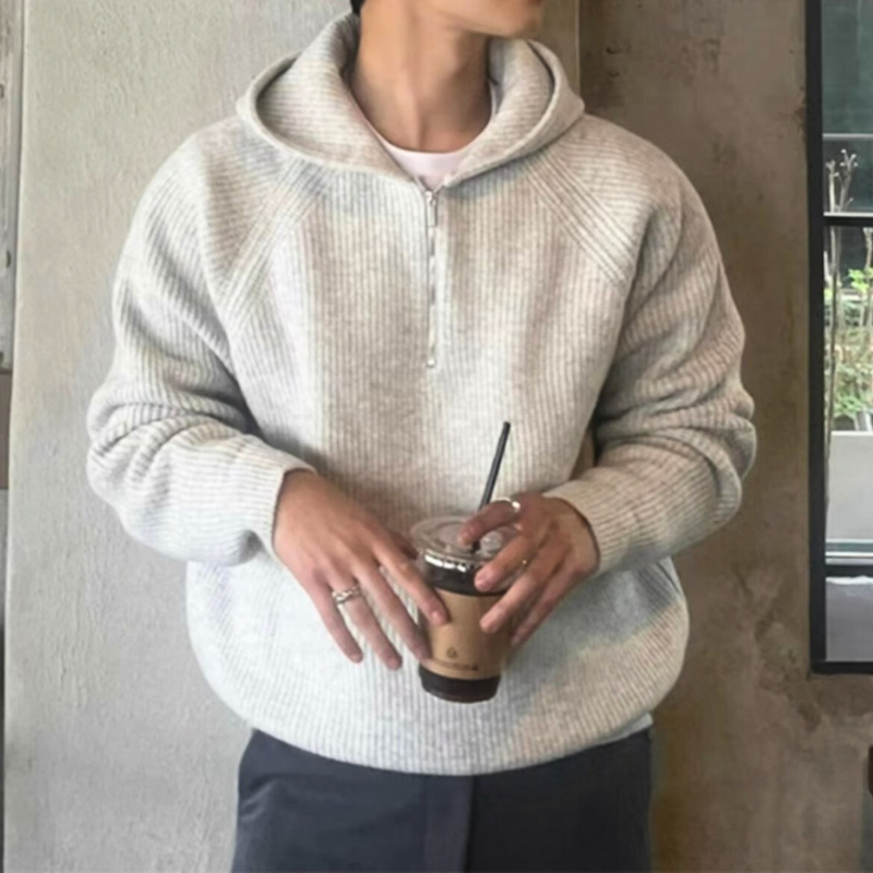 カフェで着用したライトグレーニットセーターを正面から写した男性