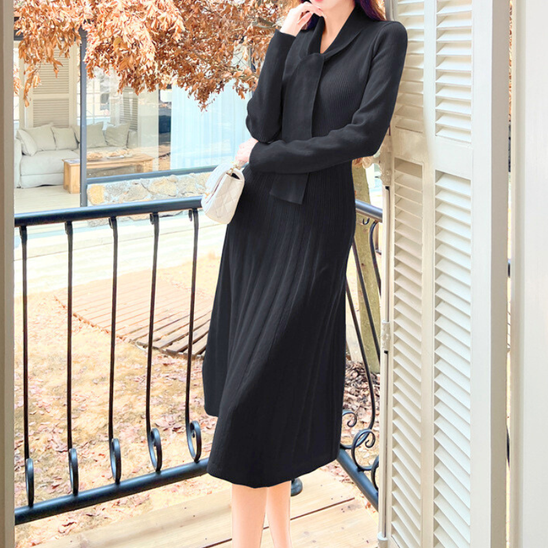 バルコニーで黒のニットワンピースを着る女性｜大人可愛いデートファッション