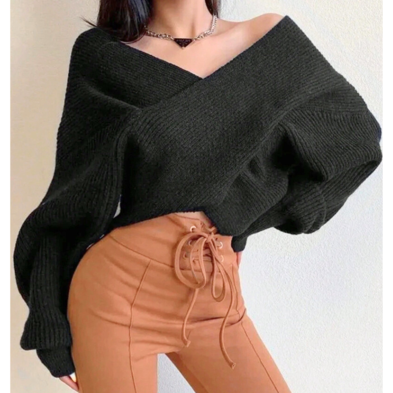 黒のオフショルニットを着た女性がウエスト周りを強調するポーズ。細見え効果が高く、男ウケの良い春秋冬コーデ。