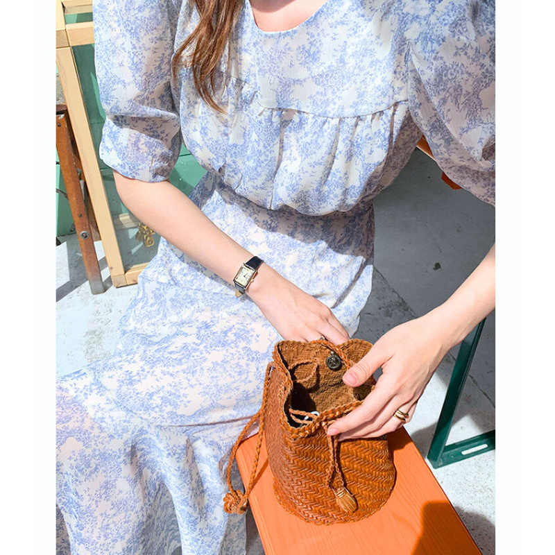 ブルートワル柄ロングワンピースの手元アップ（バッグを持つお出かけイメージ）