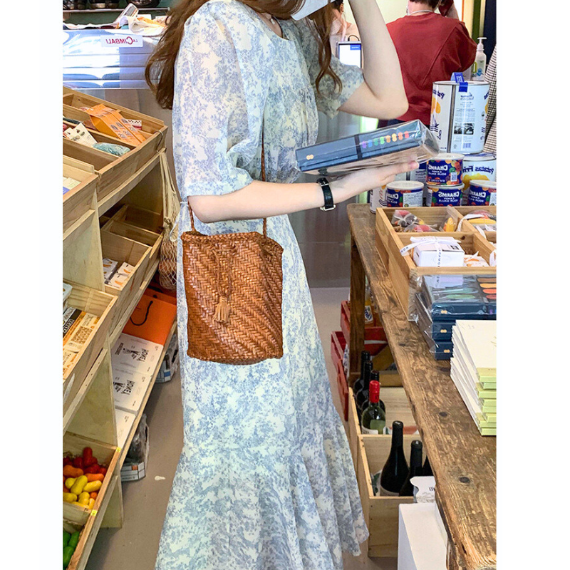 ブルートワル柄ロングワンピースの店内シーン（本を持ったコーデ）