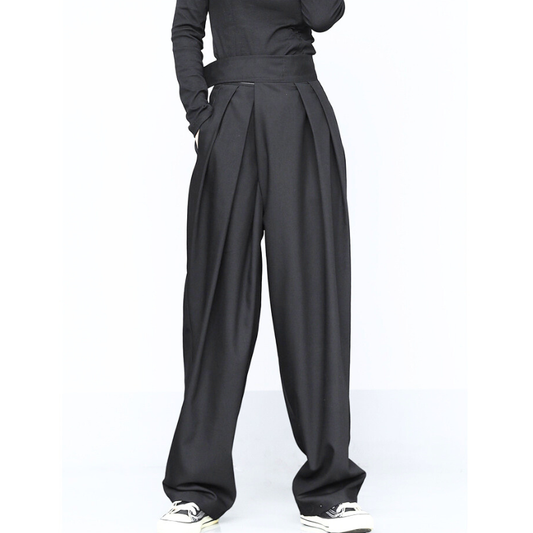 ハイウエストの黒タックワイドパンツを着用した女性の全身。脚長見えする春秋向けきれいめボトム。