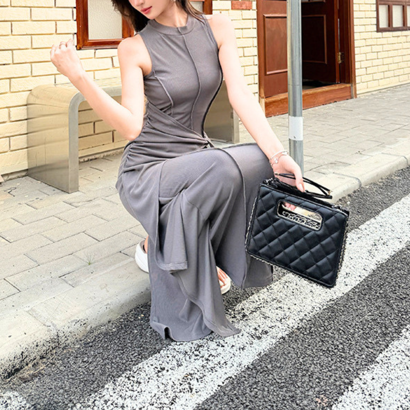 グレーのロングワンピースをバッグと合わせて着用。スリットとお出かけコーデの雰囲気が分かる写真