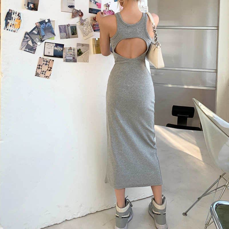 グレーのバックオープンワンピースを室内で背面から着用。背中開きとヒップラインが分かる写真