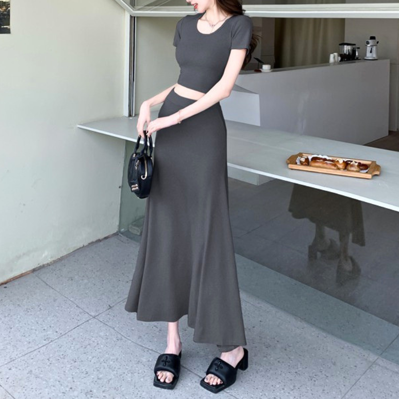 グレーのセットアップを横向きで着用。トップス丈とスカートのラインが分かる写真