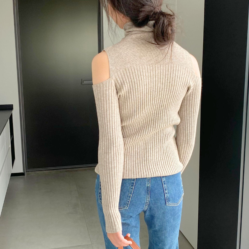 ベージュのハイネックニットトップスの後ろ姿。背面の肩カットアウトと縦リブが分かる写真