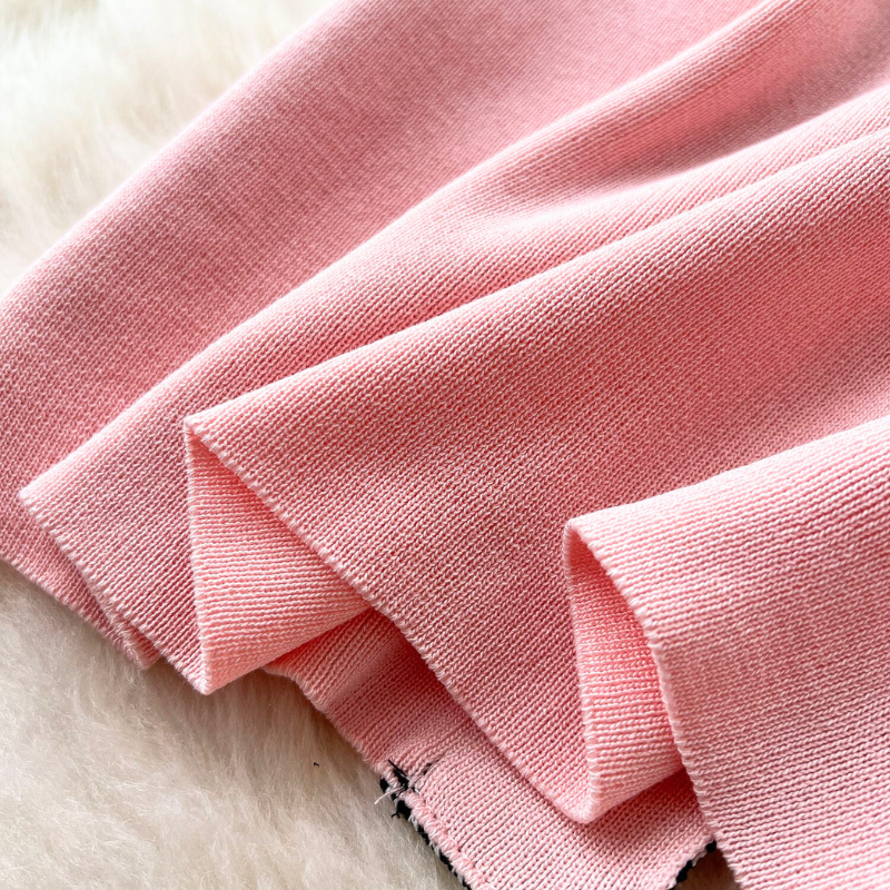 柔らかなピンクニットの生地感を写したアップショット。春らしい質感。