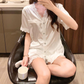 椅子に座り、ホワイトのショートパンツを着用。光沢あるアイスシルク素材が涼しげで夏にぴったり