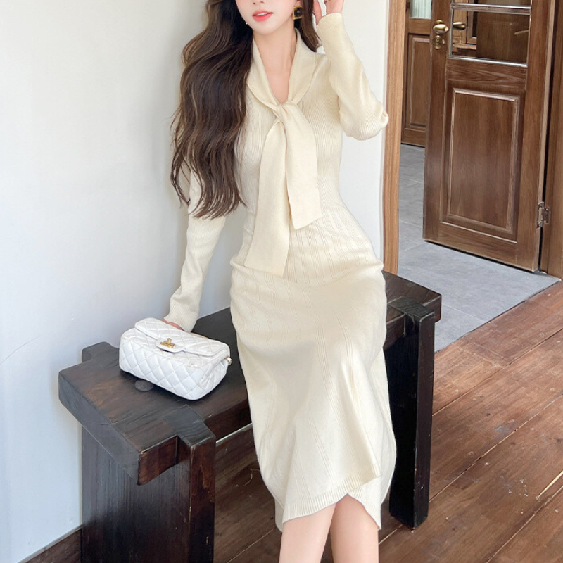 ソファに座る女性のリボンタイニットワンピースコーデ｜柔らかな印象の男ウケ服